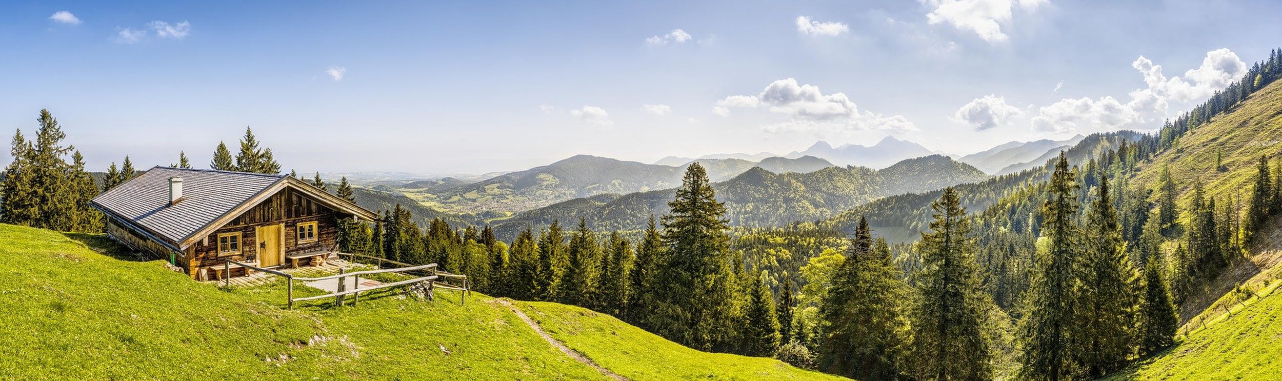 A lodge overlooks a forested mountain range.